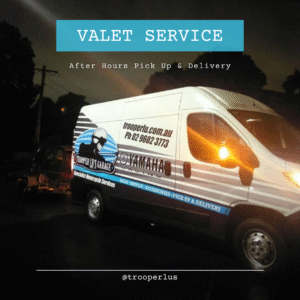 A white van labeled "Trooper Lu's Garage" and "Yamaha" is parked on a dim street at night. Text above reads, "Standard Bike Transport - After Hours: Valet pick up & delivery motorcycle services for Sydney Metro.